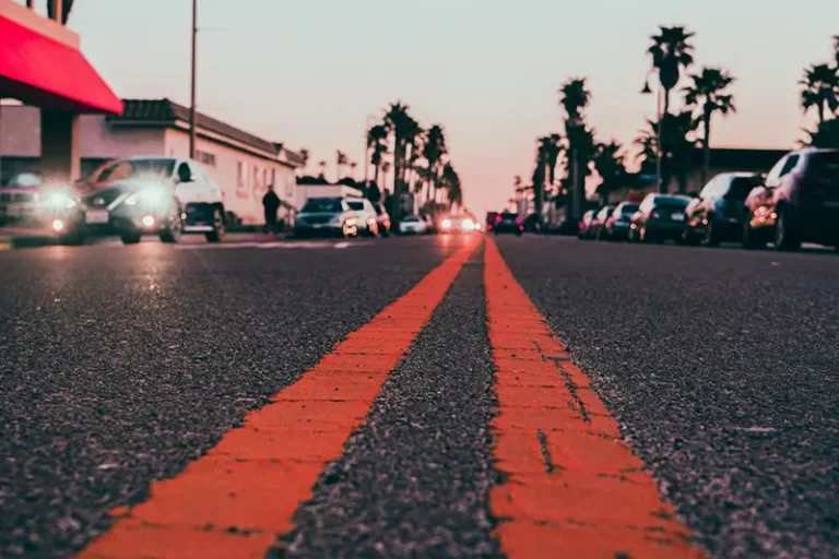 A neighborhood in San Diego shown from a low perspective in the middle of a road with double yellow lines.