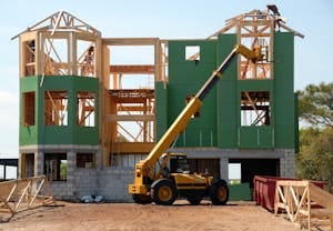 Yellow and Black Heavy Equipment Near Unfinished Building